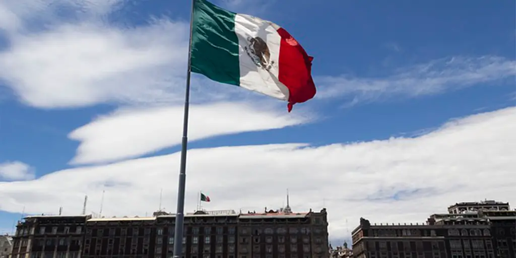 Bandeira mexicana tremulando em uma praça movimentada